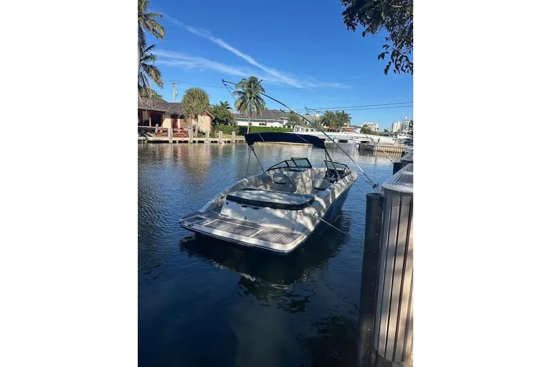 Slide: The Image of 2022 Sea Ray SPX 210 boat docked on a sunny canal with palm trees. - 11