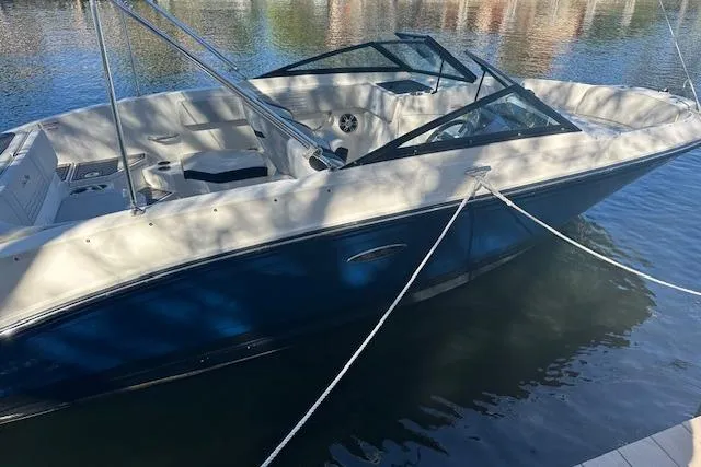 Slide: The Image of 2022 Sea Ray SPX 210 boat docked on calm water, featuring sleek design and spacious seating. - 2