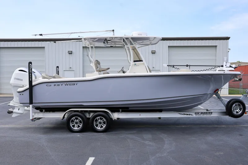The Image of 2023 Key West 263 FS boat on trailer, parked outside industrial building. - 1