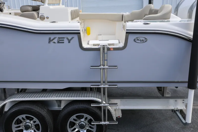 Slide: The Image of 2023 Key West 263 FS boat on trailer with ladder and seating area. - 16