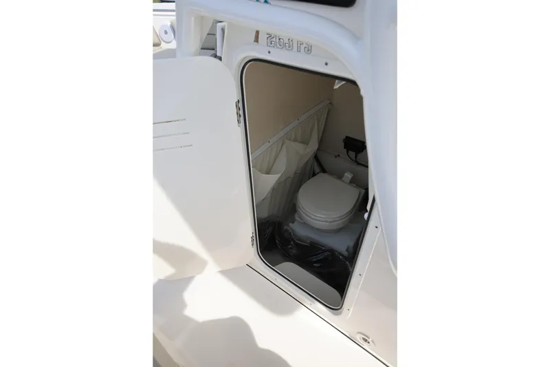 Slide: The Image of 2023 Key West 263 FS boat interior with open door revealing compact toilet. - 30