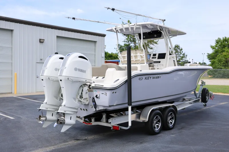 Slide: The Image of 2023 Key West 263 FS boat on trailer with twin Yamaha engines, parked outdoors. - 4