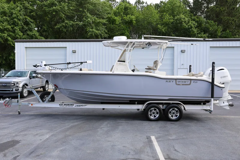 Slide: The Image of 2023 Key West 263 FS boat on trailer, parked outdoors near a building. - 7