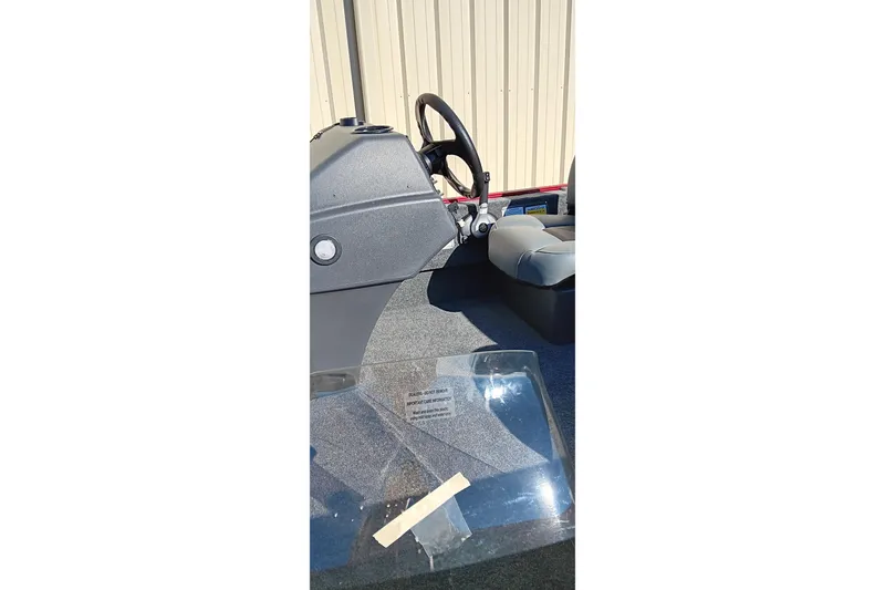 Slide: The Image of 2026 Tracker Bass Tracker Classic XL boat interior with steering wheel and seating. - 13