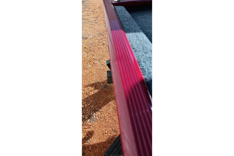 Slide: The Image of Close-up of 2026 Tracker Bass Tracker Classic XL boat edge on gravel surface. - 16