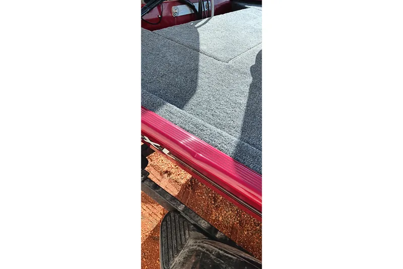 Slide: The Image of 2026 Tracker Bass Tracker Classic XL boat deck with gray carpet and red trim. - 18