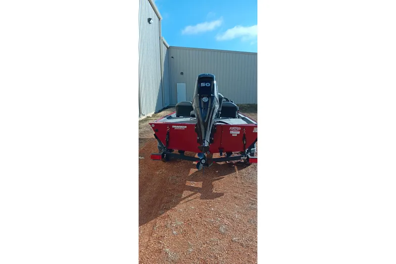 Slide: The Image of 2026 Tracker Bass Tracker Classic XL boat with 50 HP engine, parked outdoors. - 2