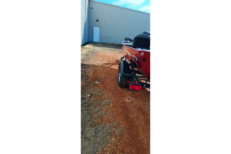 Slide: The Image of 2026 Tracker Bass Tracker Classic XL boat on a trailer near a building. - 23