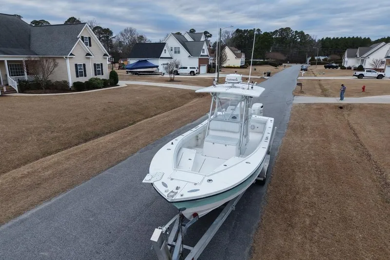 Slide: The Image of 2003 Regulator 26 Forward Seating boat on trailer in suburban neighborhood street. - 10