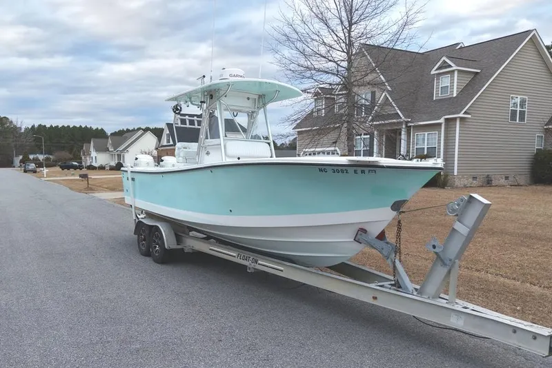 Slide: The Image of 2003 Regulator 26 Forward Seating boat on trailer in suburban neighborhood. - 12
