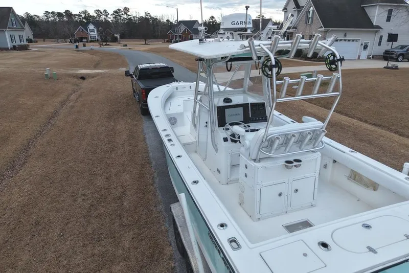 Slide: The Image of 2003 Regulator 26 Forward Seating boat on trailer in suburban neighborhood. - 17