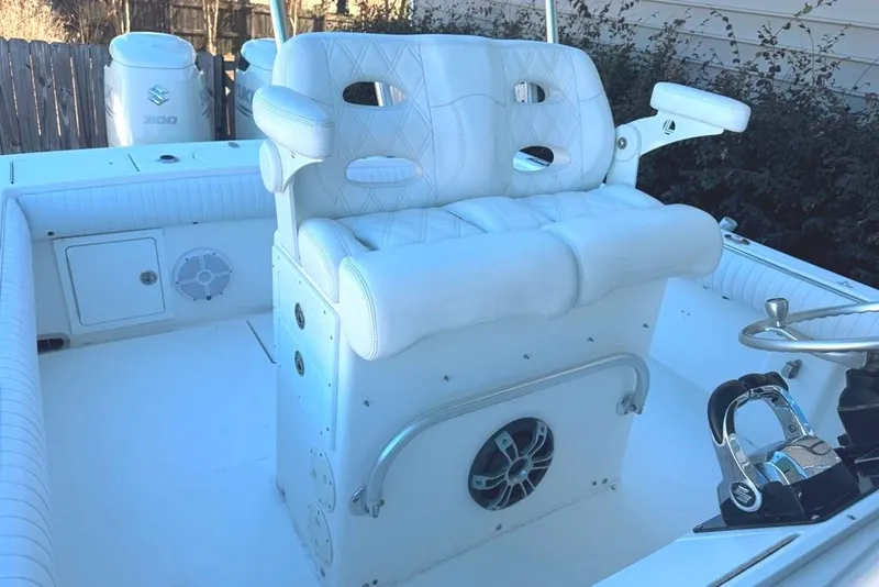 Slide: The Image of 2003 Regulator 26 Forward Seating boat interior with white cushioned helm seat and controls. - 21