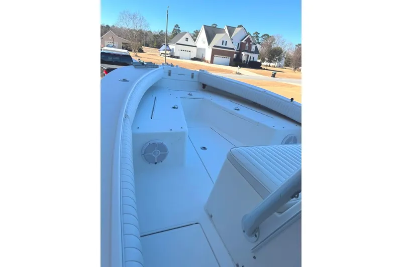 Slide: The Image of 2003 Regulator 26 Forward Seating boat with spacious deck and seating in suburban setting. - 23