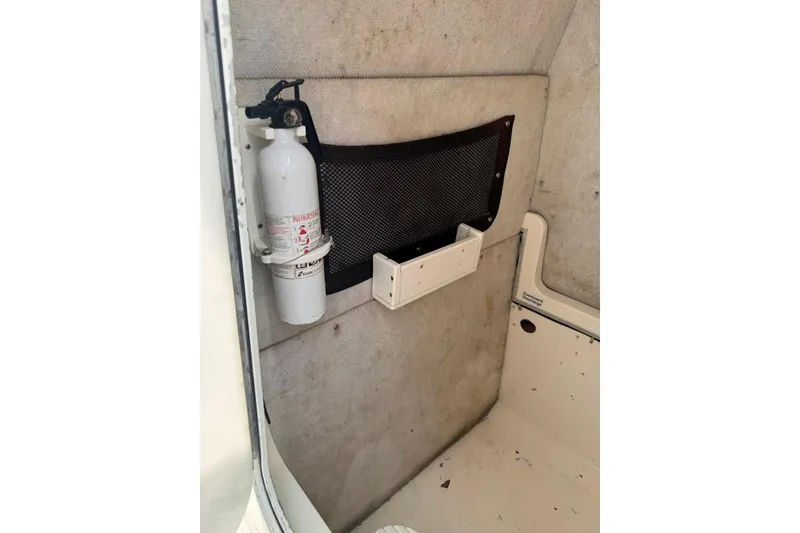 Slide: The Image of Fire extinguisher mounted inside 2003 Regulator 26 Forward Seating boat interior. - 25