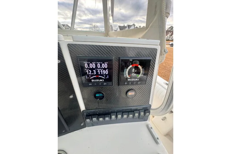 Slide: The Image of 2003 Regulator 26 Forward Seating boat dashboard with Suzuki digital gauges. - 31