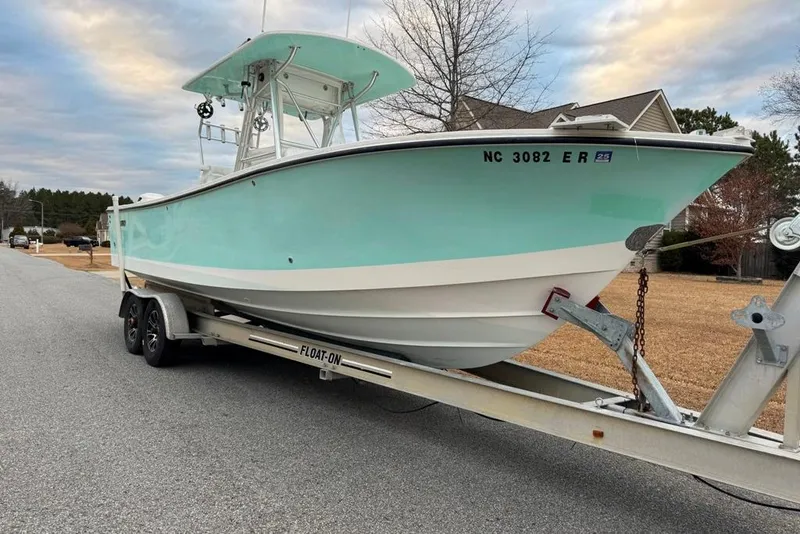Slide: The Image of 2003 Regulator 26 Forward Seating boat on trailer, parked on suburban street. - 32