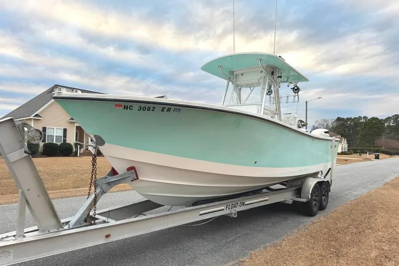Slide: The Image of 2003 Regulator 26 Forward Seating boat on trailer, parked in suburban neighborhood. - 33