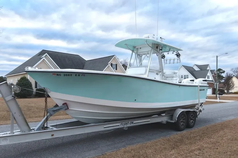 Slide: The Image of 2003 Regulator 26 Forward Seating boat on trailer in suburban neighborhood. - 9
