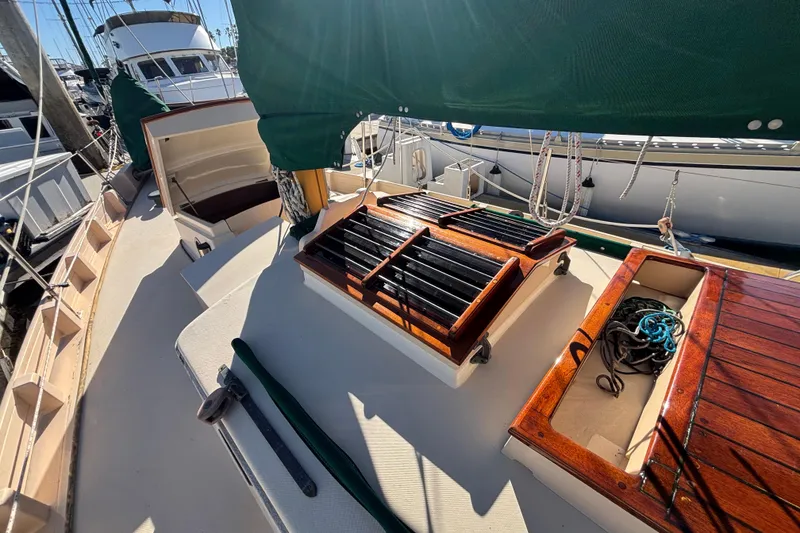 Slide: The Image of 1983 Bristol Channel Cutter 28 sailboat deck with wooden hatches and green canvas cover. - 1