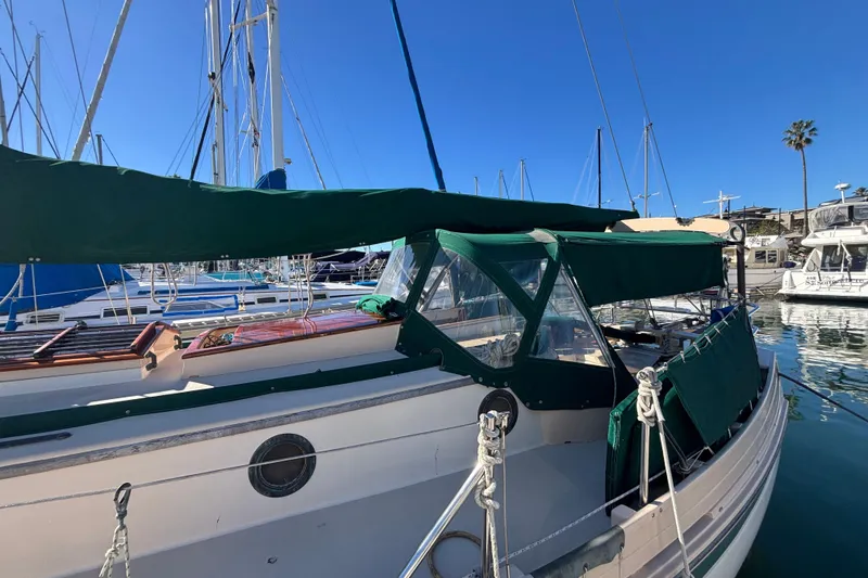Slide: The Image of 1983 Bristol Channel Cutter 28 sailboat docked in marina with green canopy. - 10