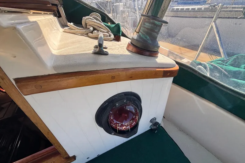 Slide: The Image of Interior of a 1983 Bristol Channel Cutter 28, featuring a compass and winch. - 16