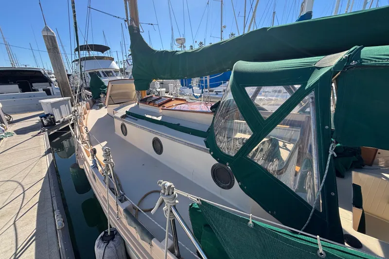 Slide: The Image of 1983 Bristol Channel Cutter 28 docked, featuring green canvas covers and classic design. - 25