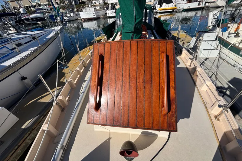 Slide: The Image of 1983 Bristol Channel Cutter 28 sailboat deck with wooden hatch, docked in marina. - 3