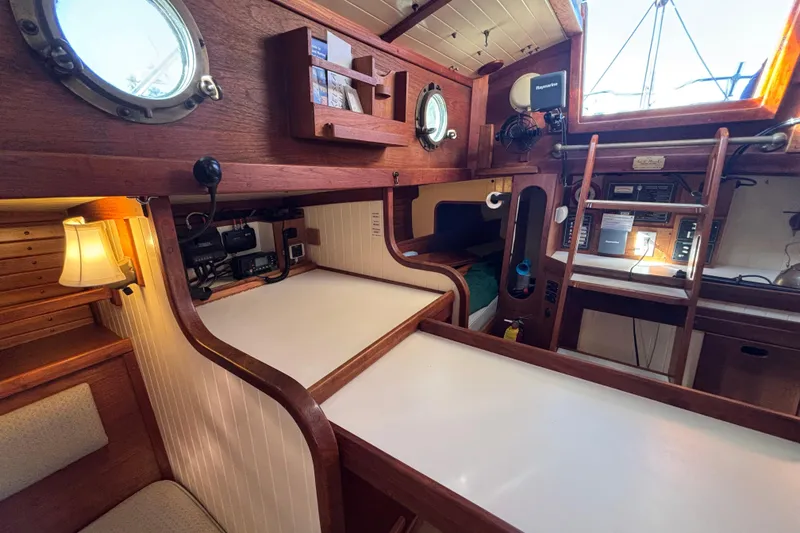 Slide: The Image of Interior of 1983 Bristol Channel Cutter 28, featuring wood paneling and nautical decor. - 30