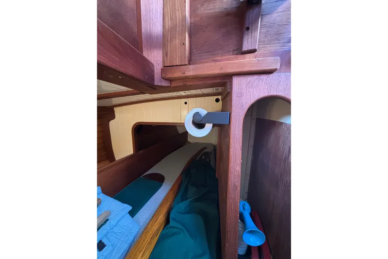 Slide: The Image of Interior of 1983 Bristol Channel Cutter 28, featuring wooden cabinetry and cozy sleeping area. - 33
