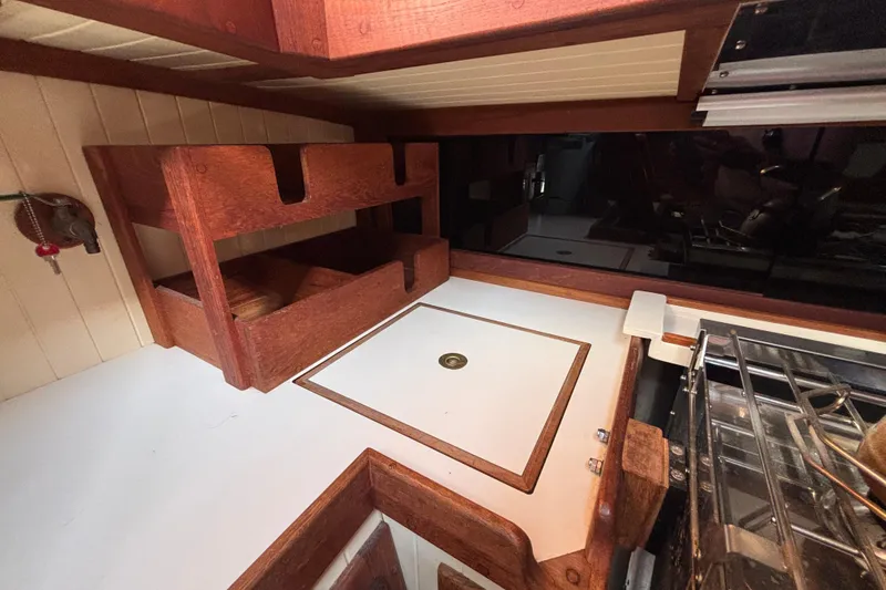 Slide: The Image of Interior of 1983 Bristol Channel Cutter 28, featuring wooden cabinetry and compact kitchen area. - 37