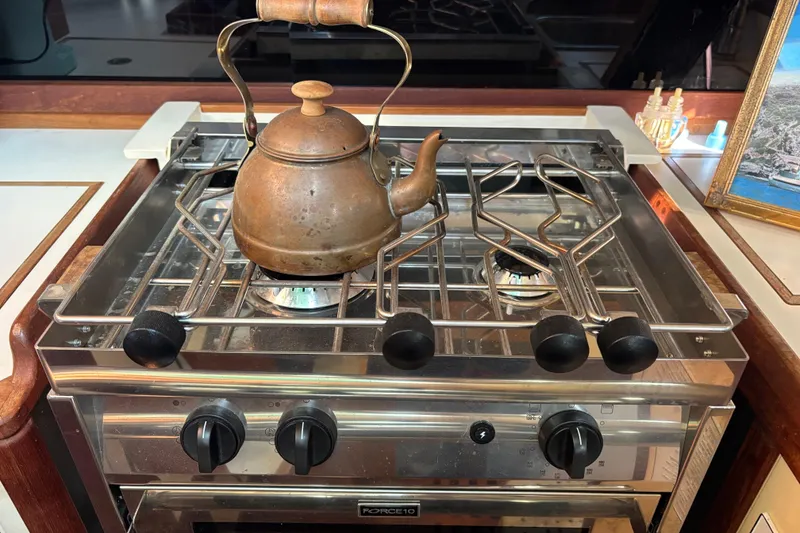 Slide: The Image of Rustic kettle on stove inside 1983 Bristol Channel Cutter boat kitchen. - 38