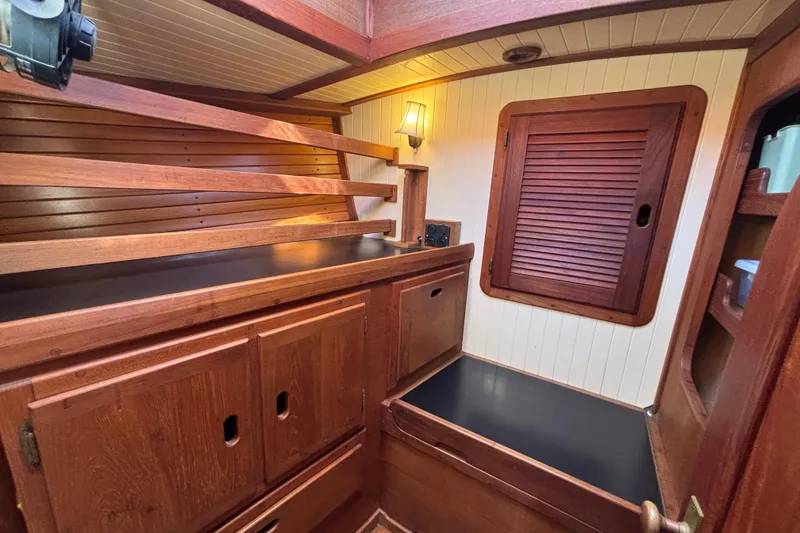 Slide: The Image of Interior of 1983 Bristol Channel Cutter 28, featuring wooden cabinetry and cozy lighting. - 52