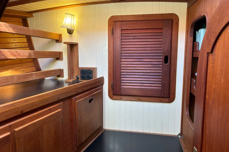 Slide: The Image of Interior of 1983 Bristol Channel Cutter 28, featuring wooden cabinetry and nautical design. - 53