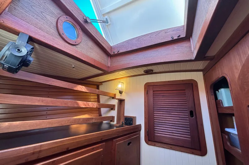 Slide: The Image of Interior of 1983 Bristol Channel Cutter 28, featuring wooden cabinetry and porthole. - 54