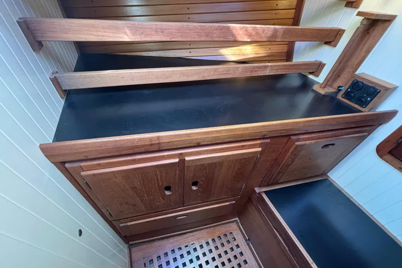 Slide: The Image of Interior of 1983 Bristol Channel Cutter 28, featuring wooden cabinetry and black countertop. - 59