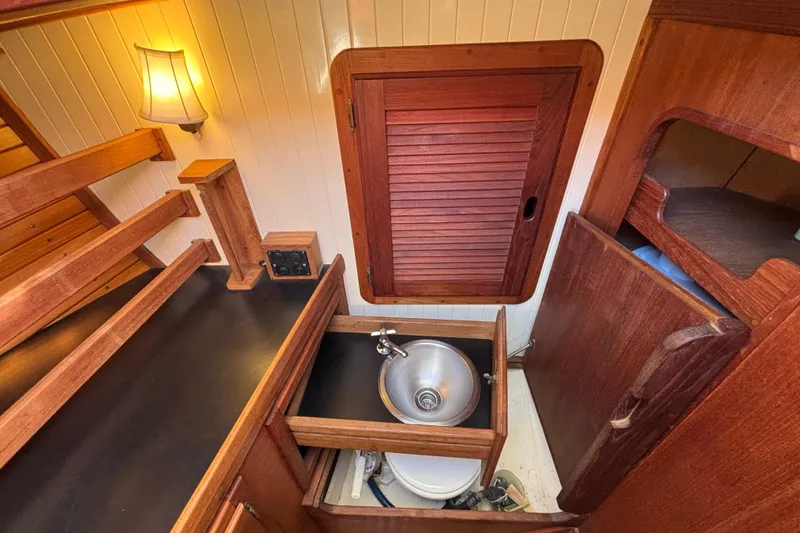Slide: The Image of Interior of 1983 Bristol Channel Cutter 28, featuring wooden cabinetry and compact sink. - 60