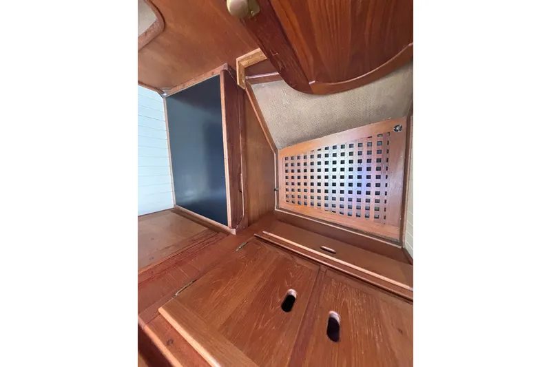 Slide: The Image of Interior of 1983 Bristol Channel Cutter 28, featuring wooden cabinetry and storage compartments. - 63