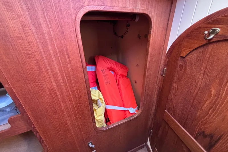 Slide: The Image of Wooden cabinet on 1983 Bristol Channel Cutter 28, storing life jackets. - 66