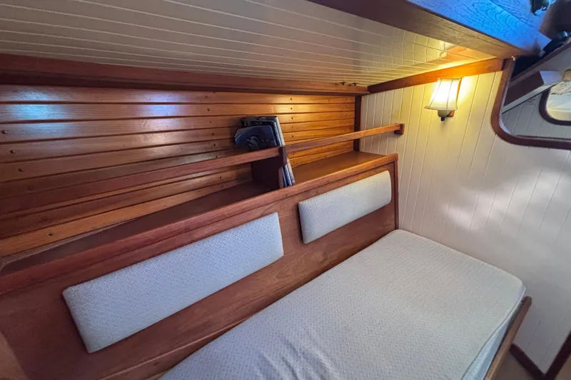 Slide: The Image of Cozy interior of 1983 Bristol Channel Cutter 28 with wooden paneling and cushioned seating. - 68