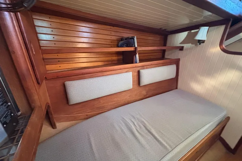 Slide: The Image of 1983 Bristol Channel Cutter 28 interior cabin with wooden paneling and cushioned seating. - 69