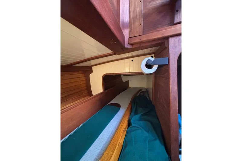 Slide: The Image of Interior of 1983 Bristol Channel Cutter 28, featuring wooden cabinetry and cozy sleeping area. - 74