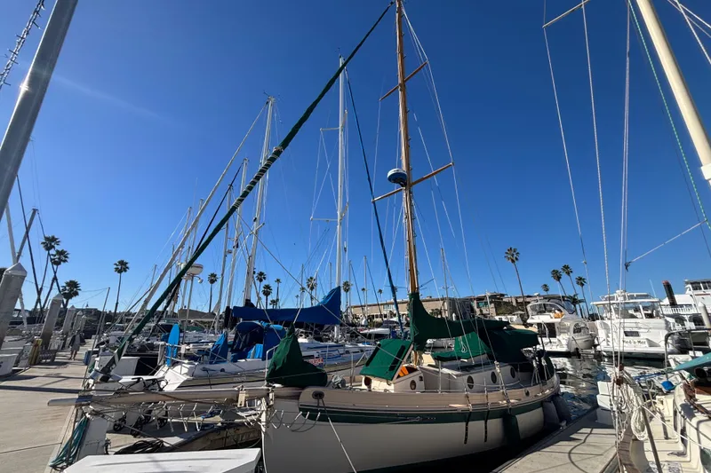 Slide: The Image of 1983 Bristol Channel Cutter 28 sailboat docked at a marina under clear blue skies. - 75