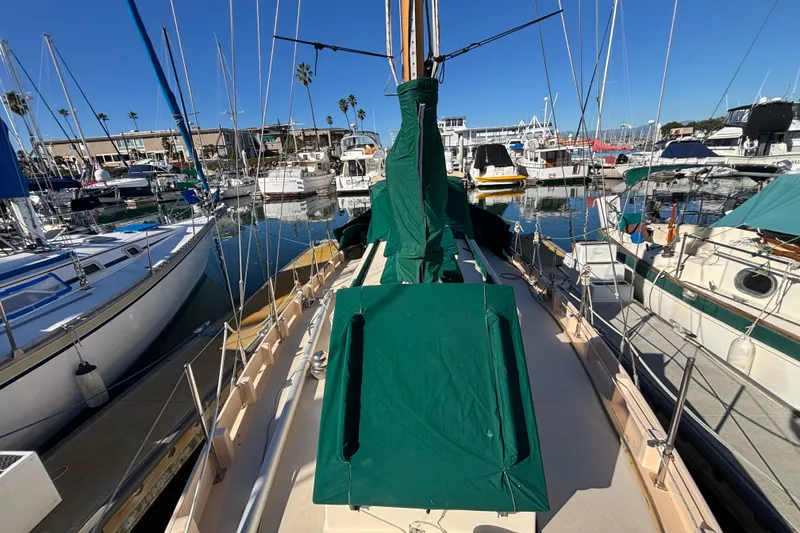 Slide: The Image of 1983 Bristol Channel Cutter 28 sailboat docked in a marina, covered in green tarps. - 80