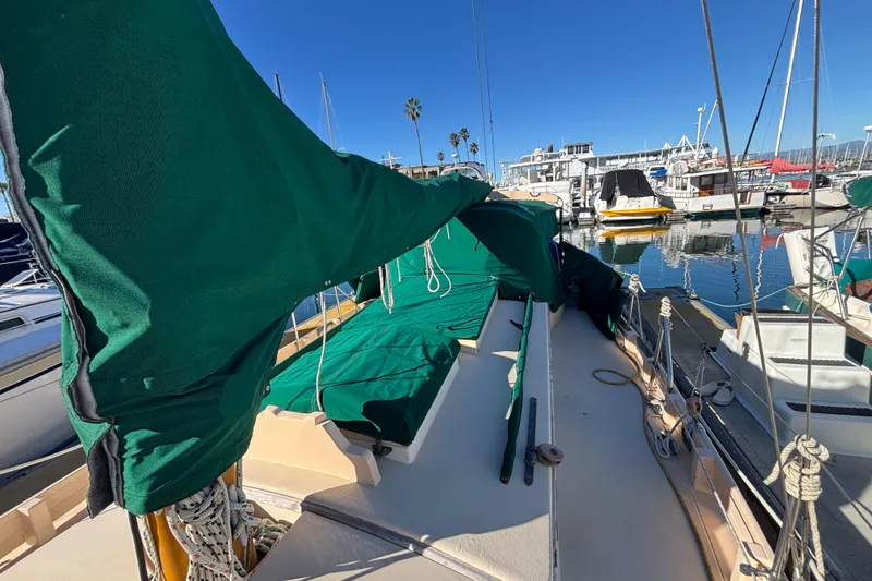 Slide: The Image of 1983 Bristol Channel Cutter 28 sailboat docked, green covers, marina background. - 81