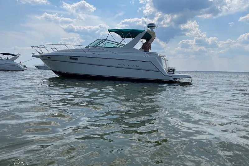 The Image of 1997 Maxum 3200 SCR boat on calm water under a partly cloudy sky. - 1