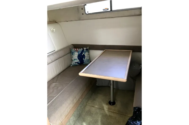Slide: The Image of 1997 Maxum 3200 SCR cabin interior with seating, table, and decorative pillow. - 12