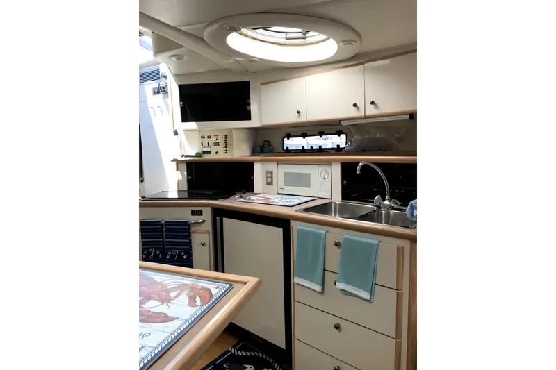Slide: The Image of Interior of 1997 Maxum 3200 SCR yacht kitchen with modern amenities and sleek design. - 13