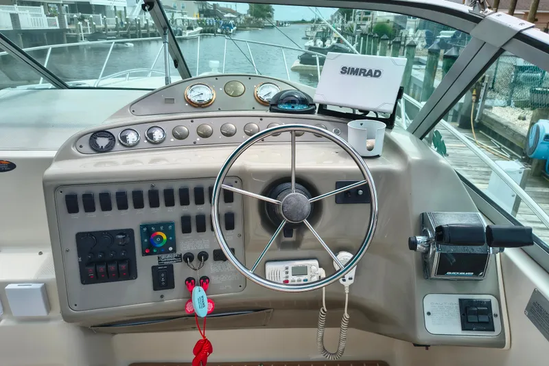 Slide: The Image of Cockpit of 1997 Maxum 3200 SCR boat with steering wheel and control panel. - 9