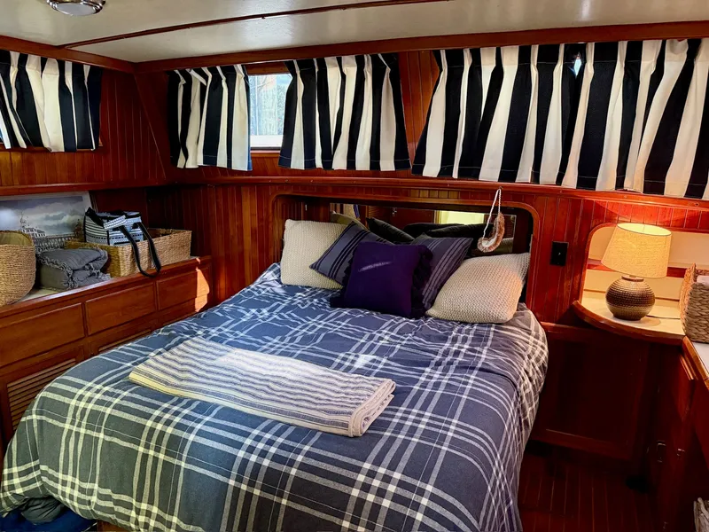 Slide: The Image of Cozy cabin on a 1988 PT 42 Yacht with striped curtains. - 14