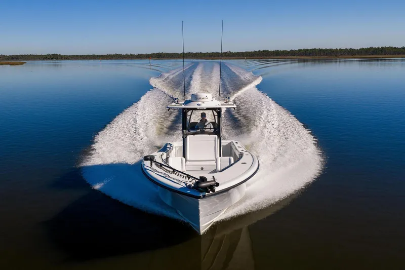 Slide: The Image of 2023 Yellowfin 32 Offshore boat cruising on calm water, creating a dynamic wake. - 18